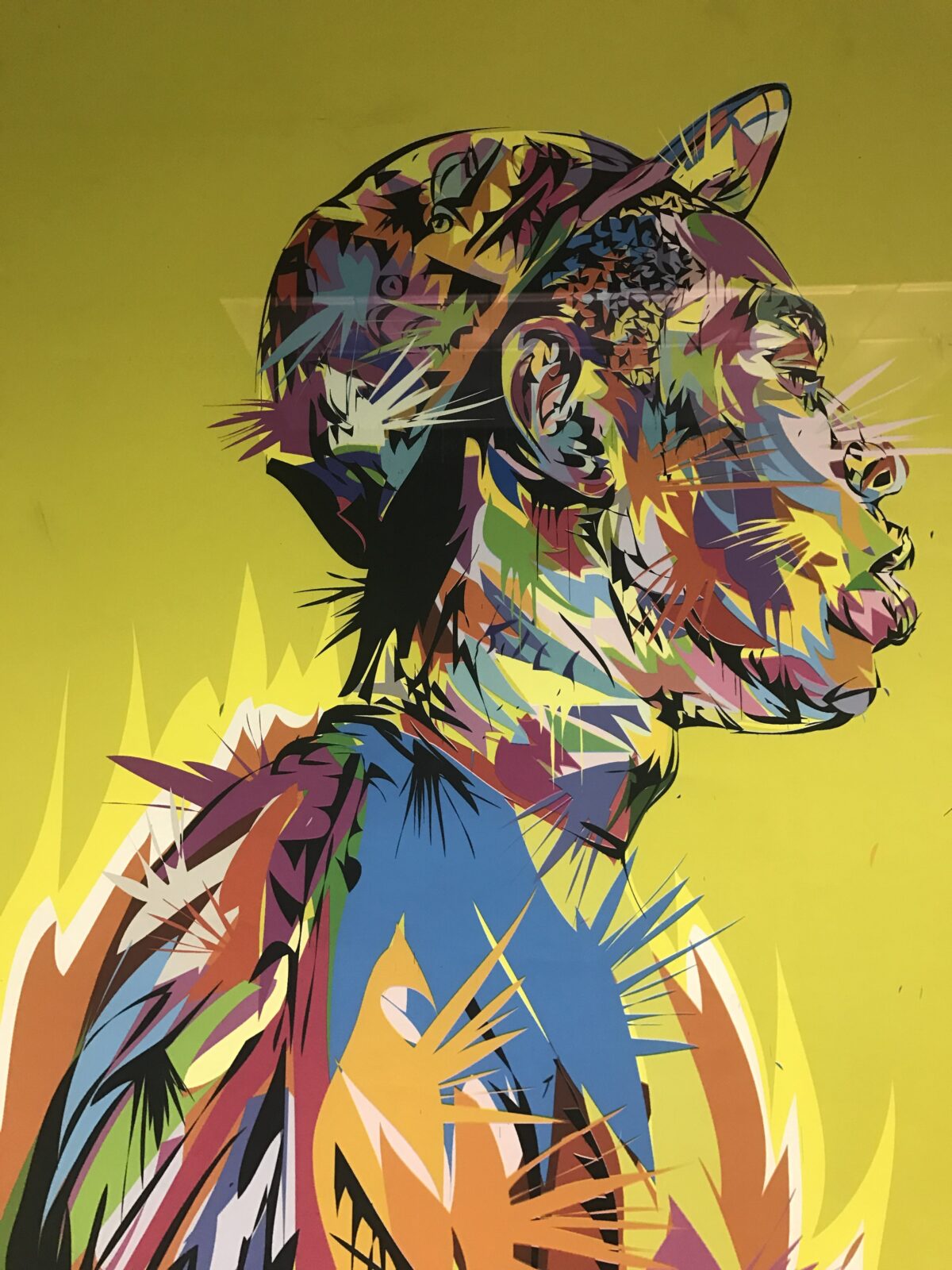 Colorful abstract graffiti art on a yellow wall.