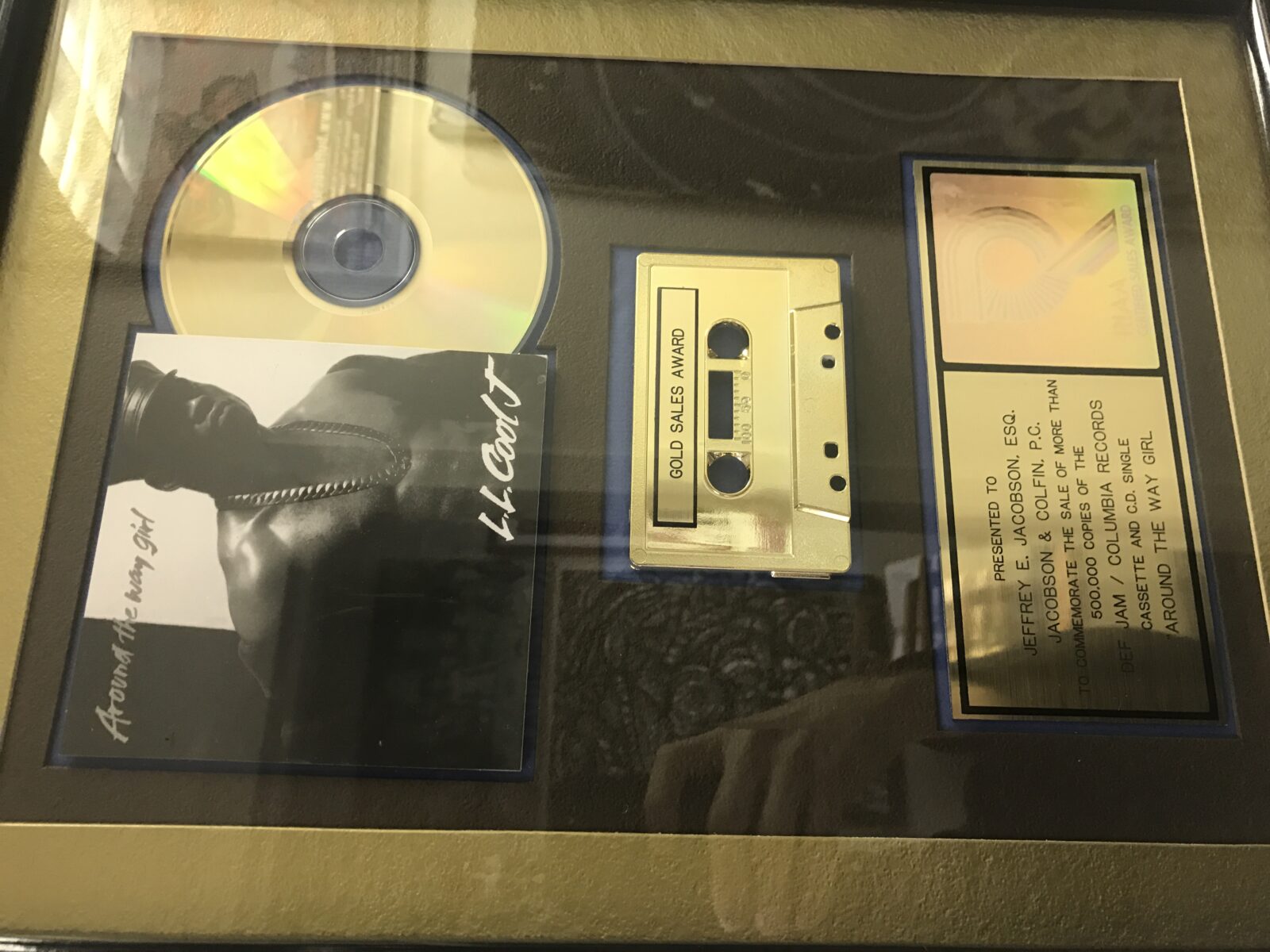 Framed gold record and cassette award display.