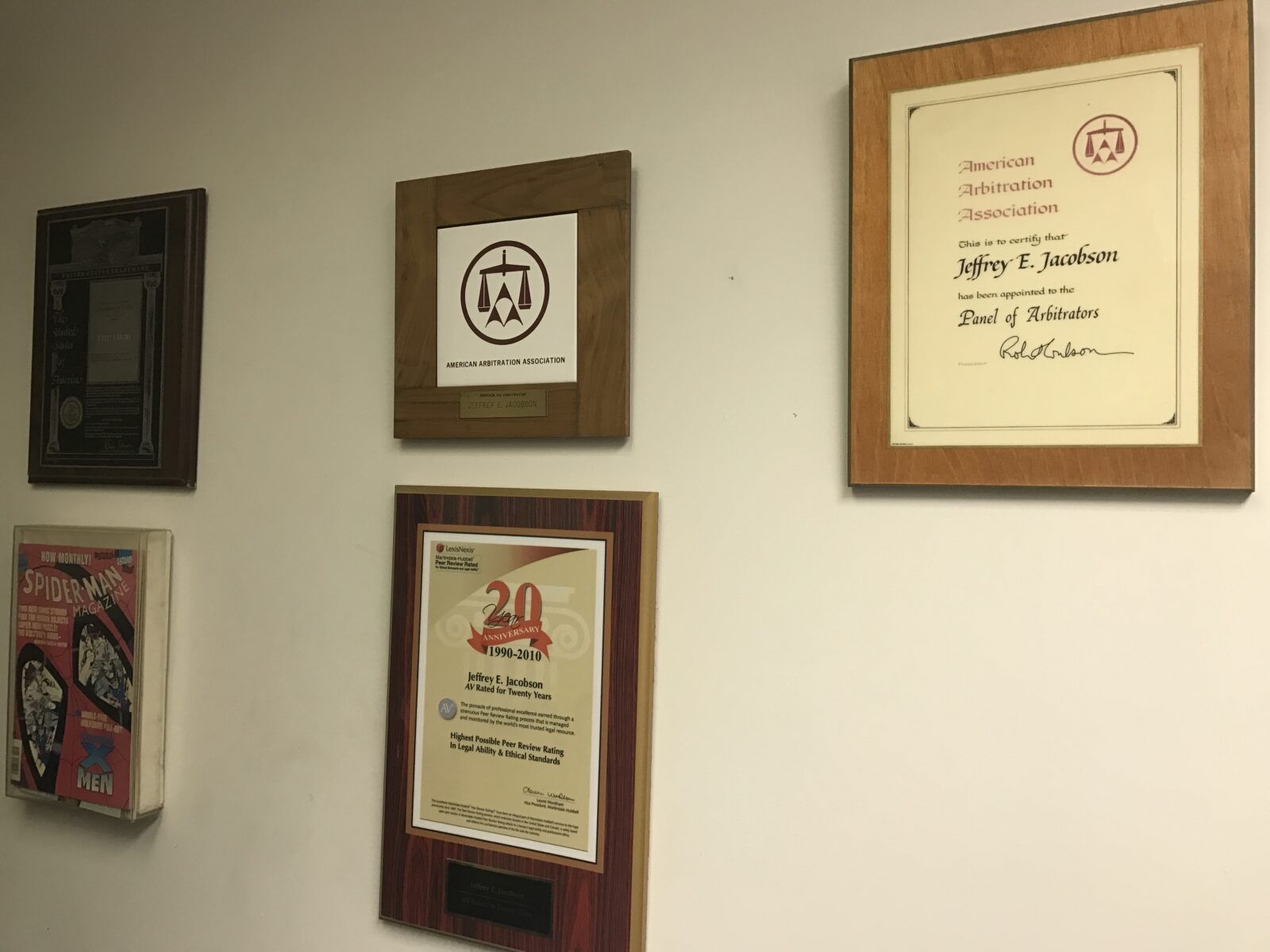 Framed certificates and awards displayed on a wall.