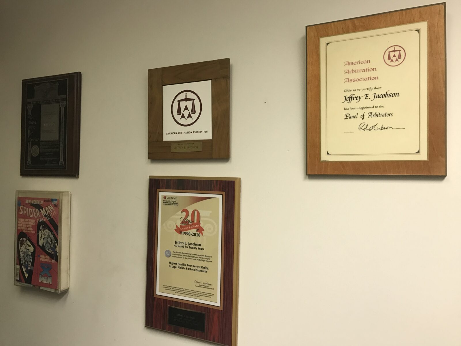Wall with framed certificates and awards in an office.