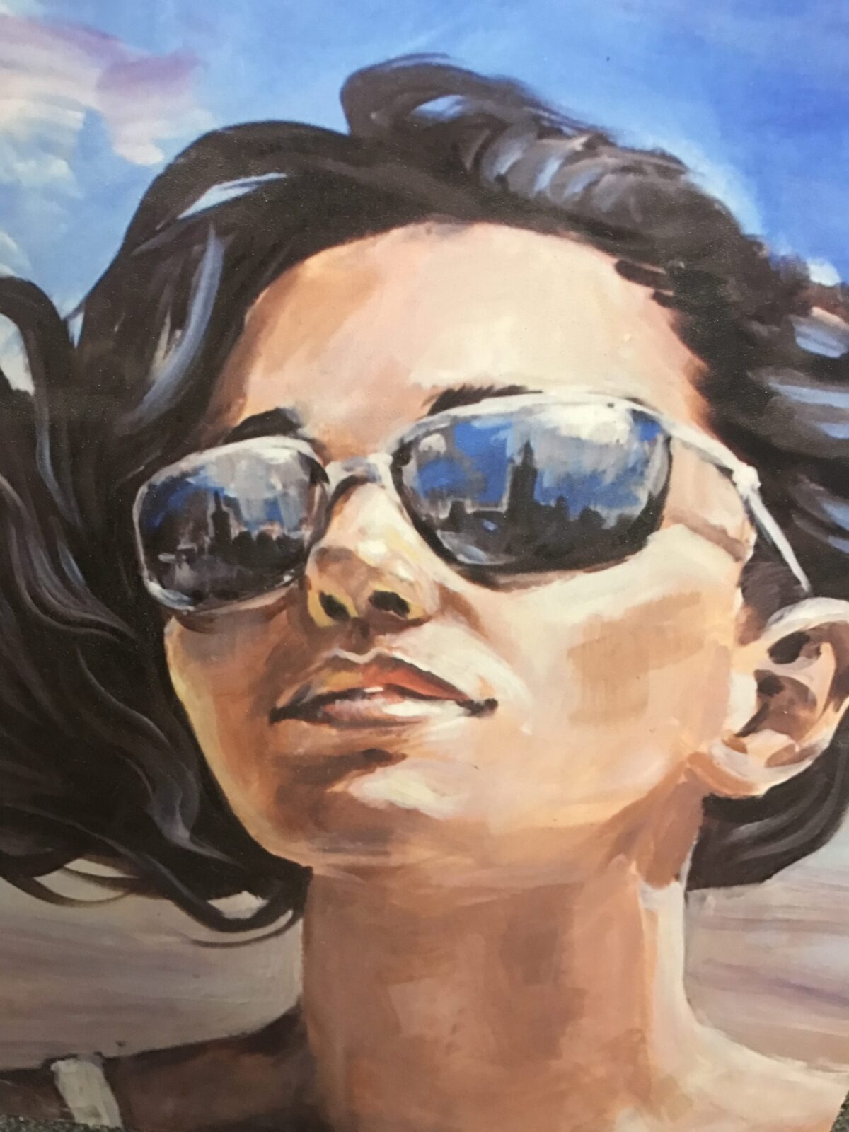 Close-up of a person wearing reflective sunglasses lying down.