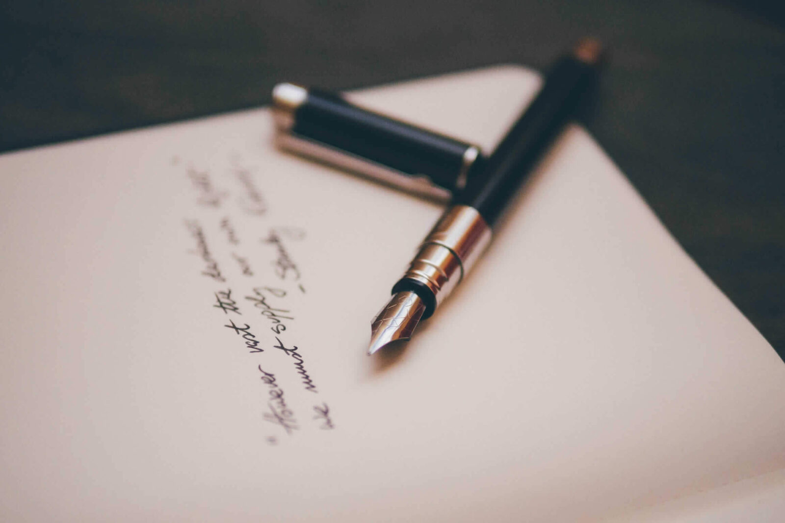 A fountain pen lying on a handwritten letter.